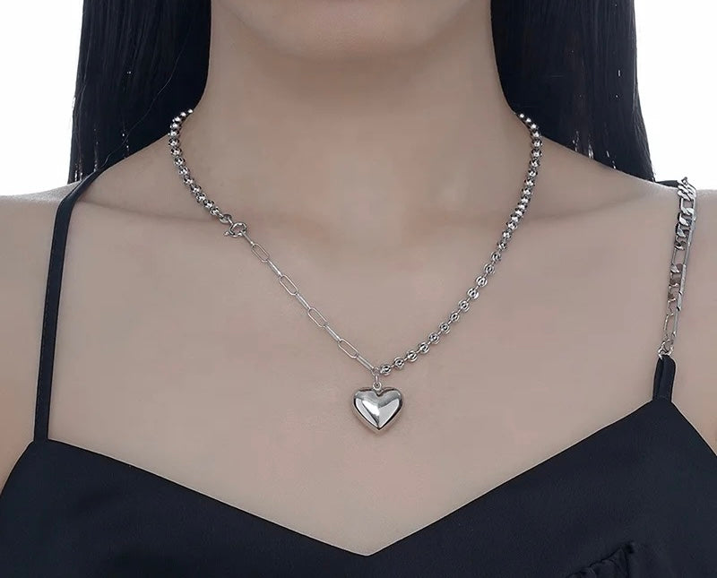 Silver necklace with heart pendant.