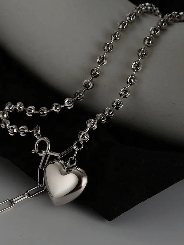 Silver necklace with heart pendant.