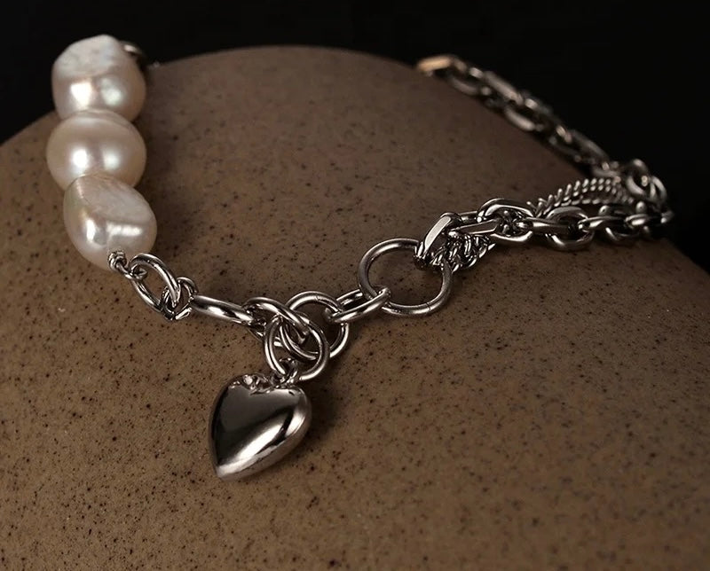 Pearl bracelet with zircons and heart pendant.