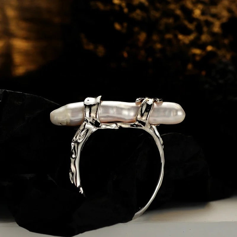 Silver ring with long pearl.