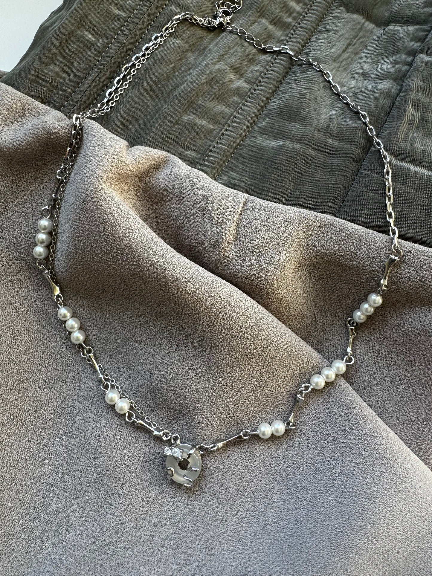 Necklace with pearls, zircons and shell stone.