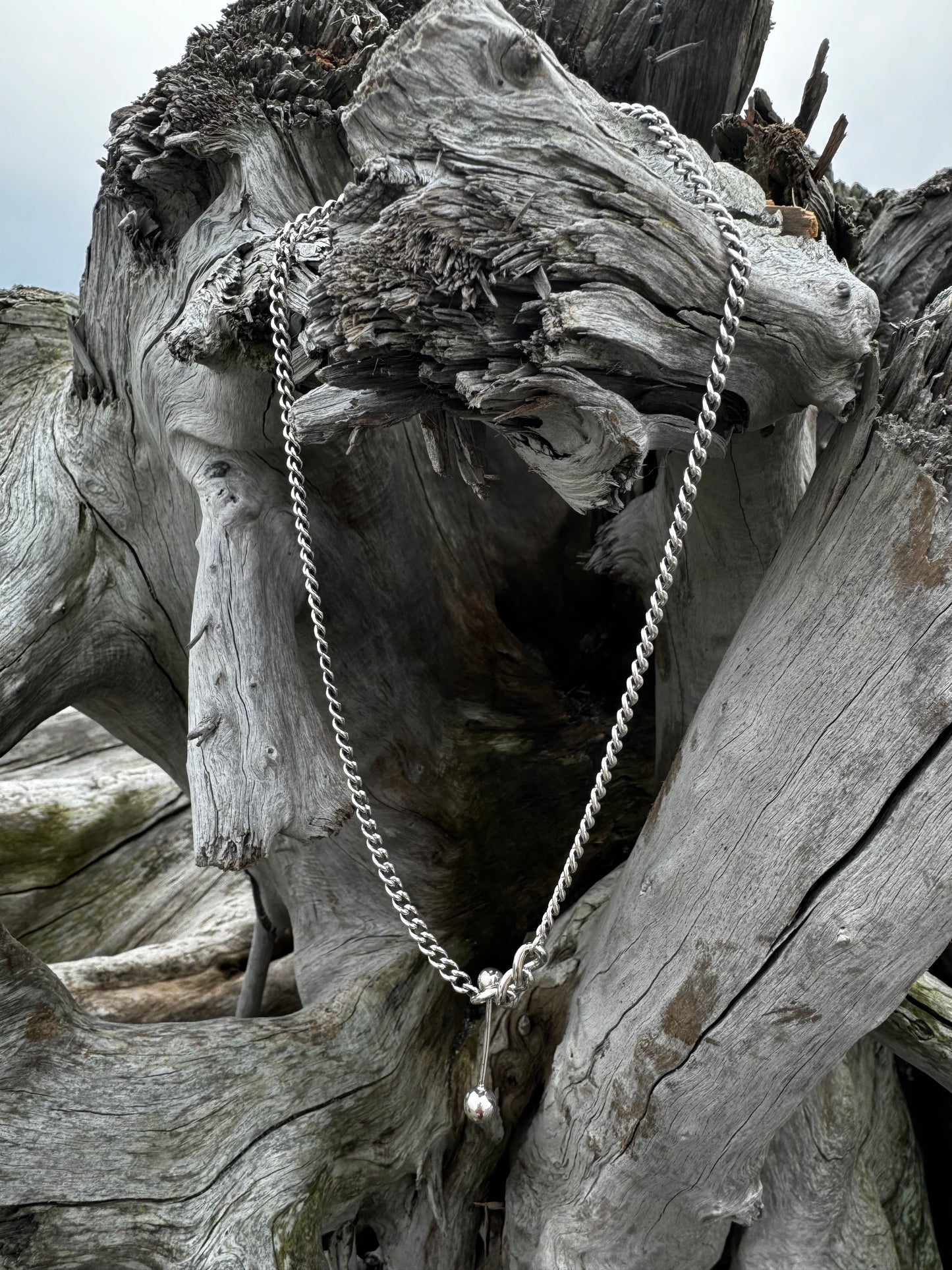 Silver necklace with decorative elements.