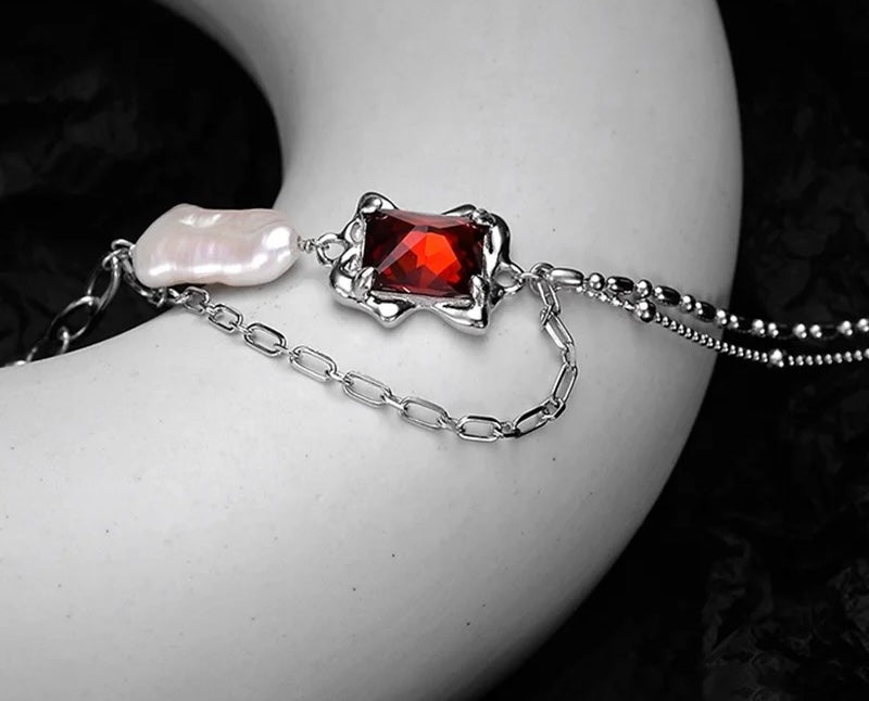 Necklace with baroque pearl and ruby crystal.