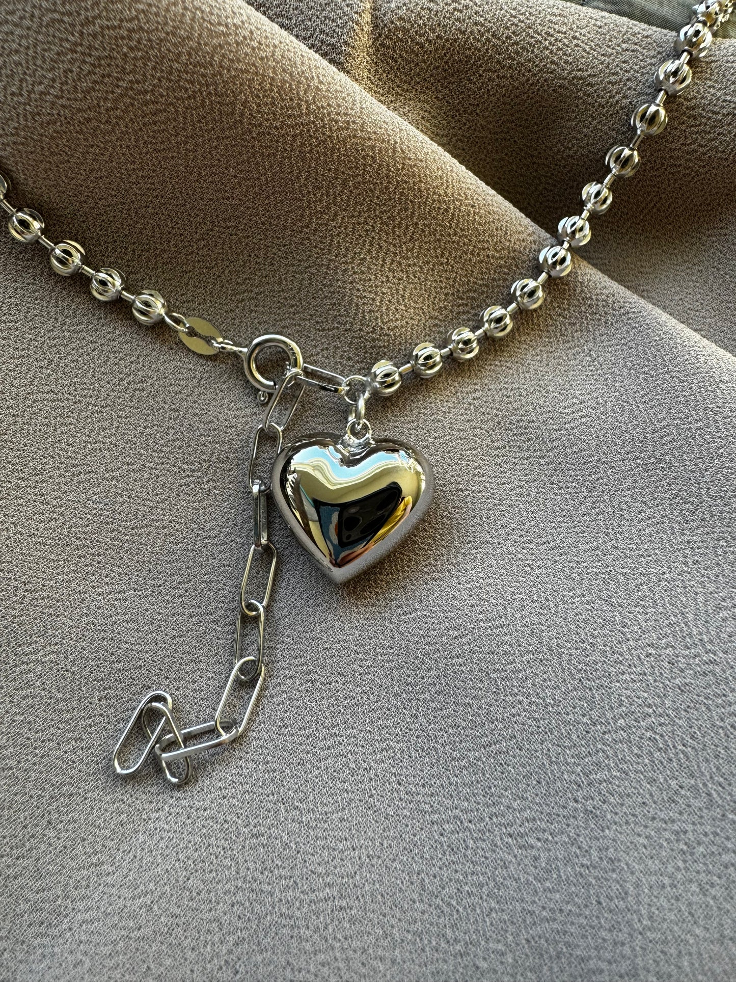 Silver necklace with heart pendant.