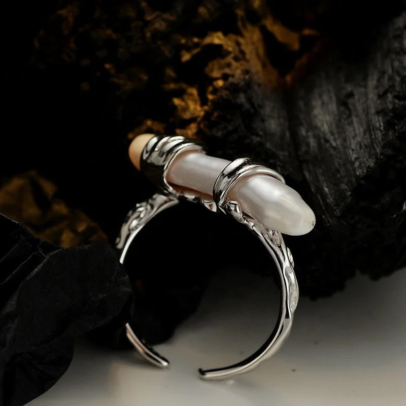 Silver ring with long pearl.