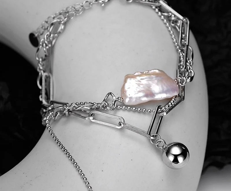 Bracelet with baroque pearl and chains.