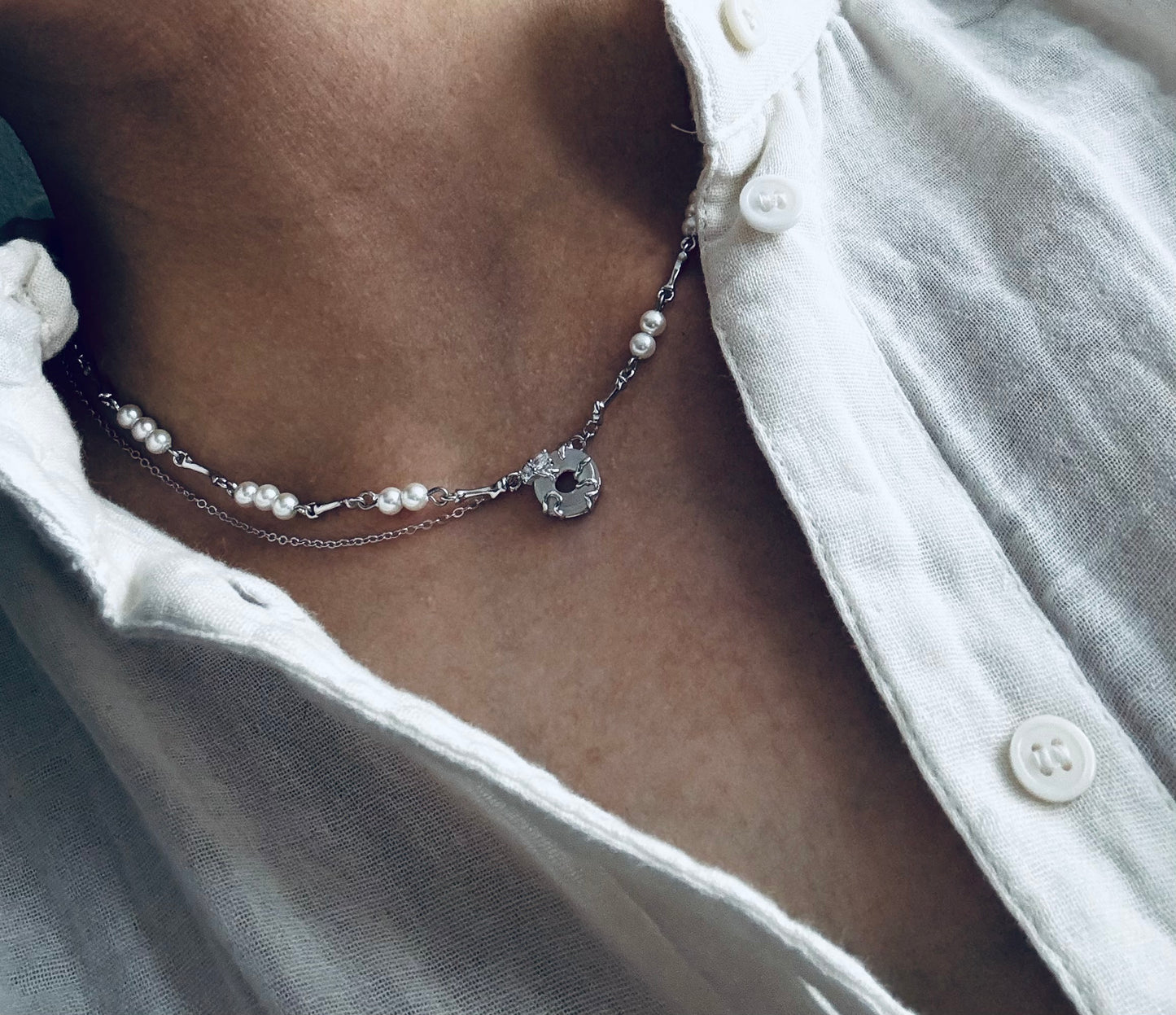 Necklace with pearls, zircons and shell stone.