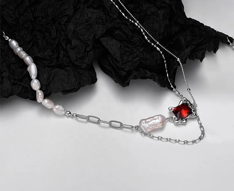 Necklace with baroque pearl and ruby crystal.
