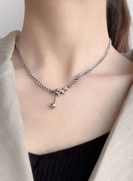 Silver necklace with decorative elements.