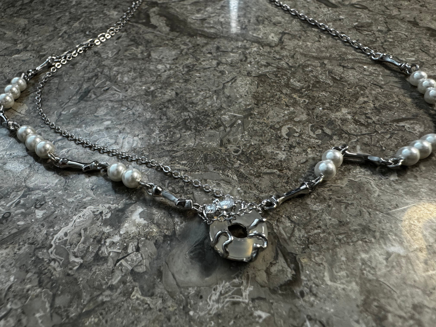 Necklace with pearls, zircons and shell stone.