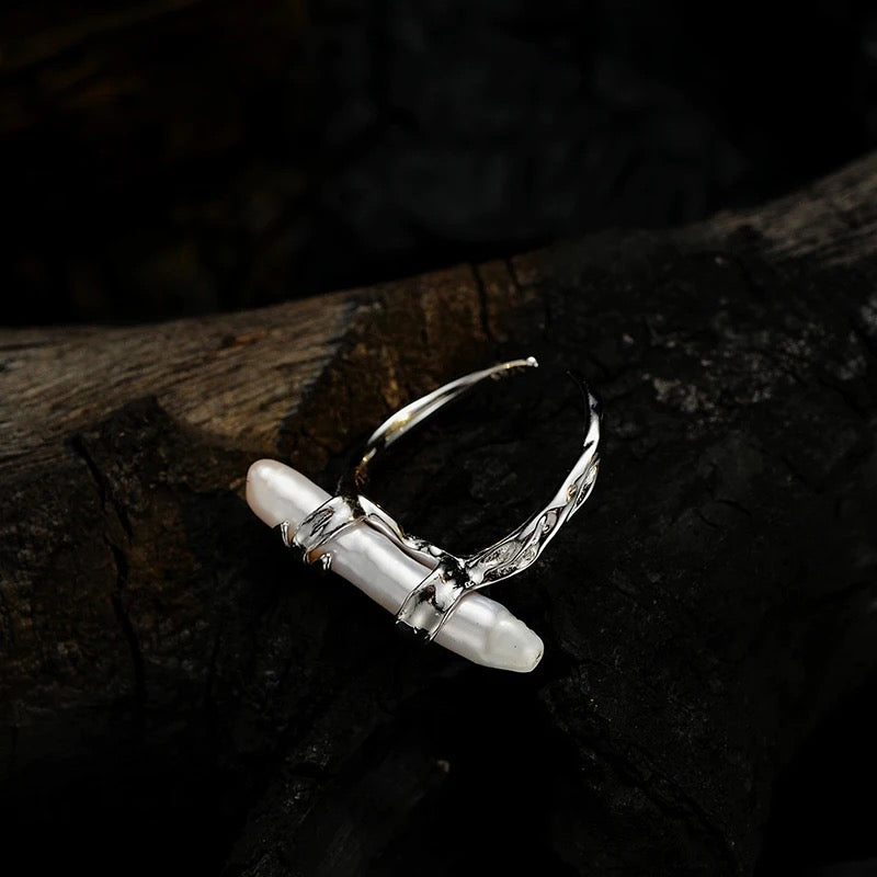 Silver ring with long pearl.