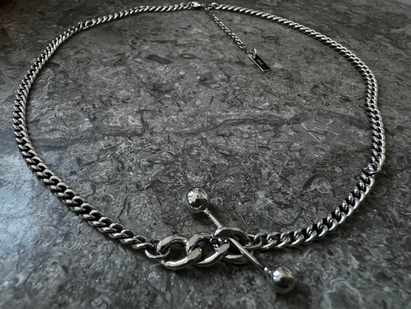 Silver necklace with decorative elements.