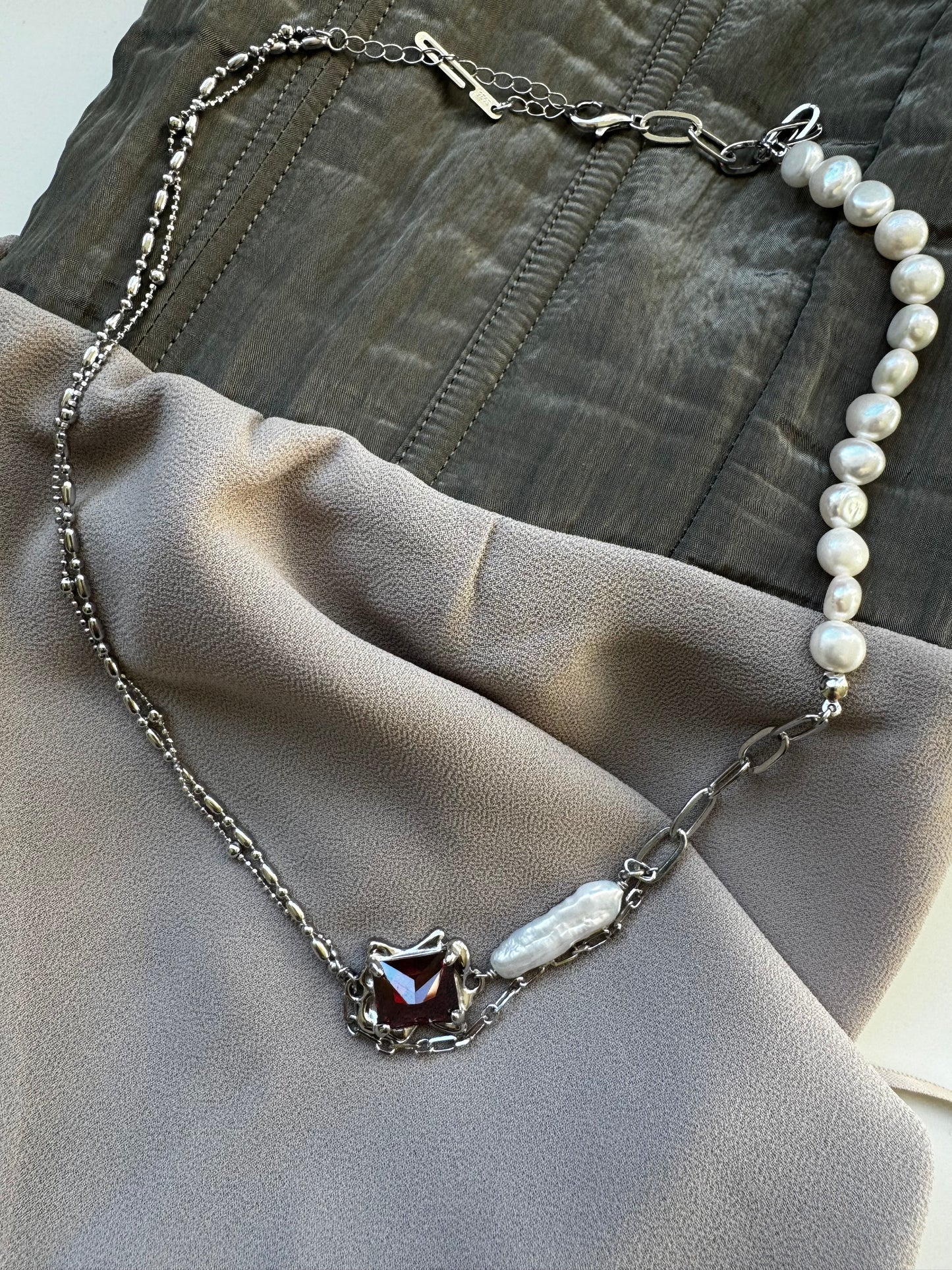 Necklace with baroque pearl and ruby crystal.