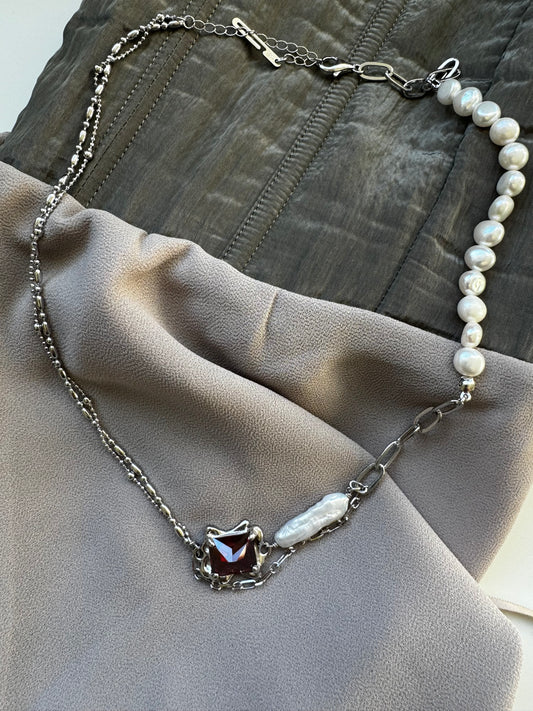 Necklace with baroque pearl and ruby crystal.