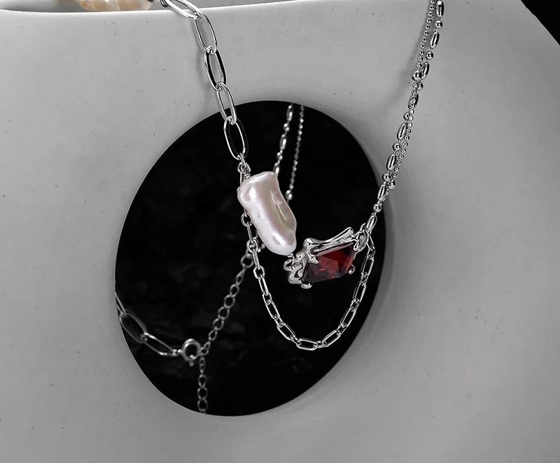 Necklace with baroque pearl and ruby crystal.